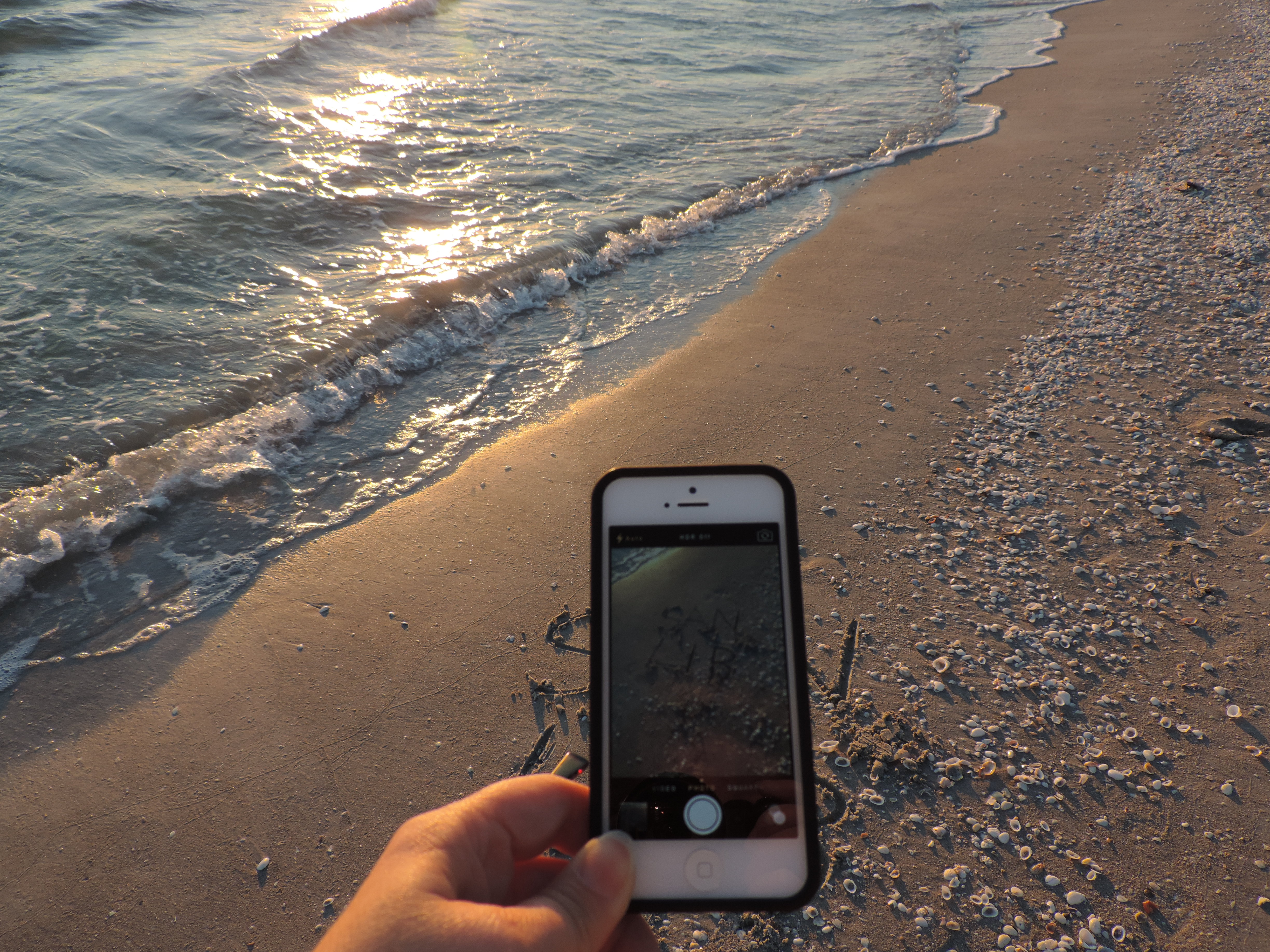 Photo of phone taking a photo on the beach.