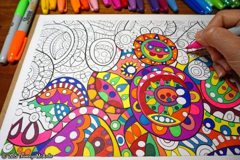 a picture of a half finished coloring sheet with a hand coloring in the left corner