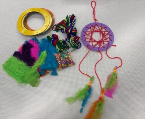 Completed dreamcatcher project with yarn, beads, feathers and hoops
