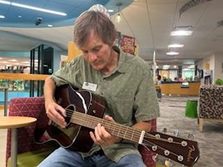 Mr. John with acoustic guitar