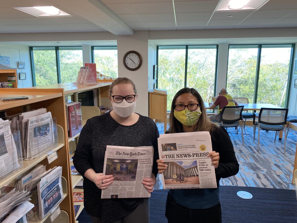 Beth Jarrell & Florinda Patterson holding newspapers